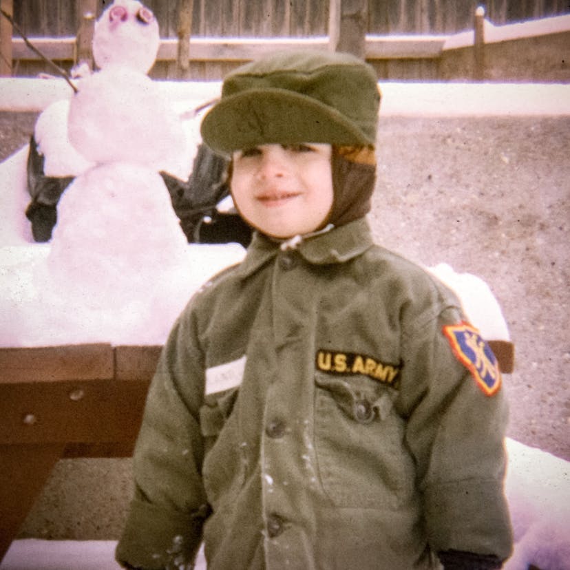 Boots as a kid in the snow, dressed in an army hat and coat.